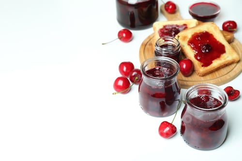 Preview: Cherry jam sandwiches and ingredients on white background