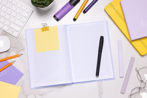 Preview: Open planner and stationery on light marble table, flat lay