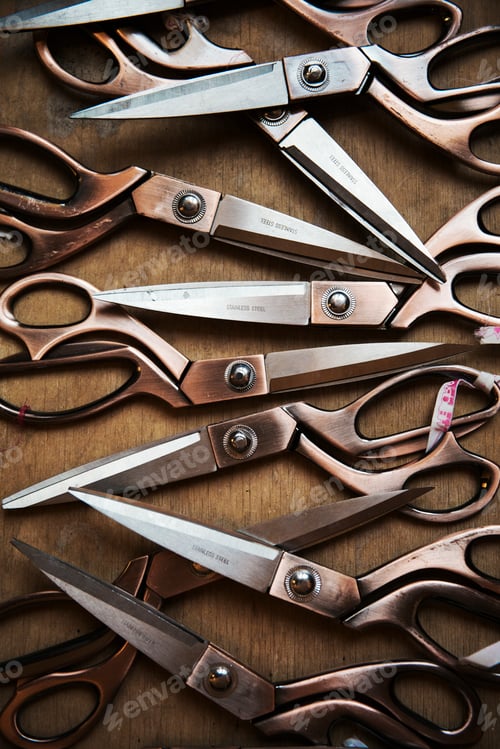 Preview: A row of used and worn scissors on a tabletop.