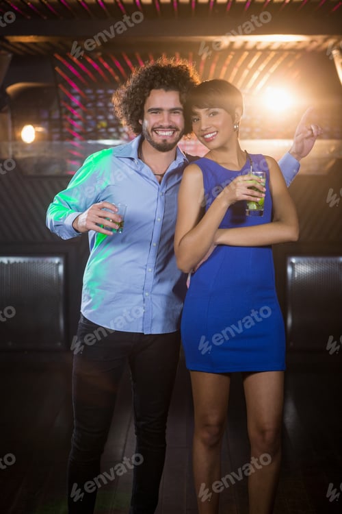 Preview: Portrait Of Couple Dancing Together On Dance Floor While Having Drink In Bar