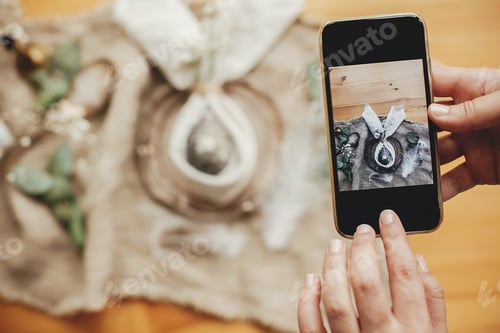 Preview: Taking photo of stylish Easter flat lay table setting with egg in easter bunny napkin on phone