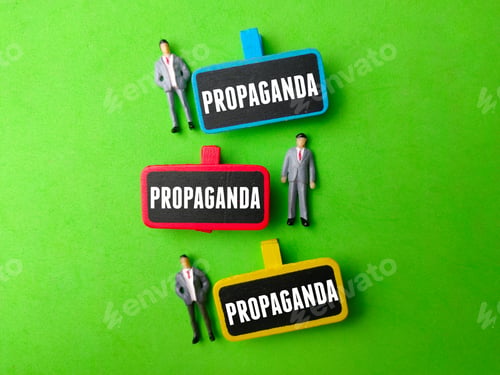 Preview: Miniature people and wooden board with the word PROPAGANDA on green background.