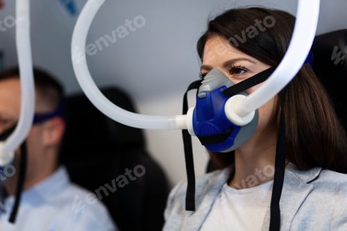 Preview: Female patient wearing oxygen mask during hyperbaric oxygen therapy.