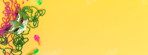 Preview: Mardi gras accessories flat lay on bright yellow background, web banner