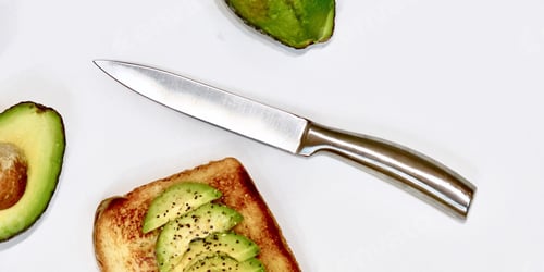 Preview: Stainless steel knife, avocado cut in half and toast with avocado slices sprinkled with lemon pepper
