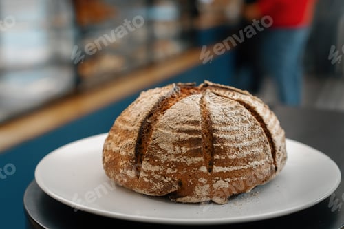 Preview: Close-up, bakery - freshly baked dark bread on rotating surface