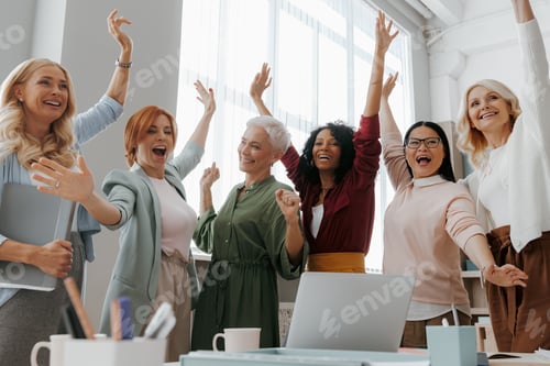 Preview: Group of mature businesswomen gesturing and smiling while having meeting in office
