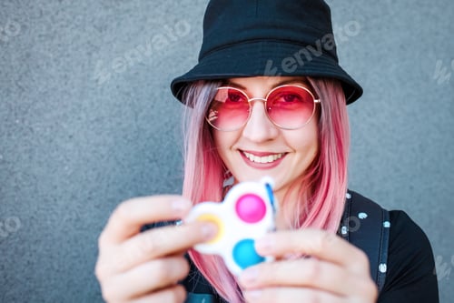 Preview: Young Girl Holding pink Pop It Fidget Toy in hands. Teen Playing