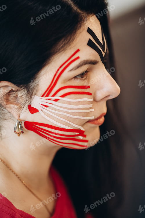 Preview: Woman receiving kinesio taping treatment on face for pain relief