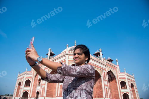 Preview: Indian woman taking selfie with smartphone in front of Humayun's Tomb