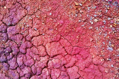 Preview: Travel to Ural, Russia. The view on the red and purple dry cracked soil for background.T
