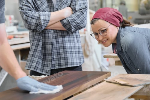 Preview: Woodworking workshop, worker varnishing wooden shelf closeup