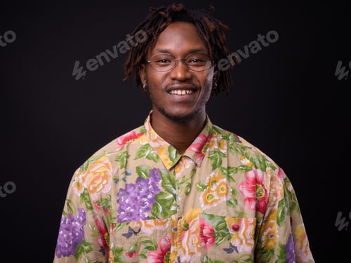 Preview: Young African man with dreadlocks against black background