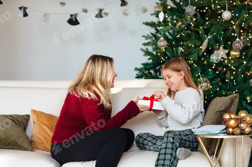 Preview: Woman Giving Gift to Girl by Christmas Tree