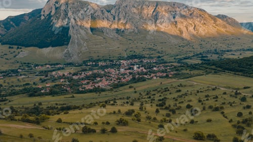 Preview: Aerial view of Rimetea, Romania. Grass meadow with wild bushes and the limestone rock. Drone.