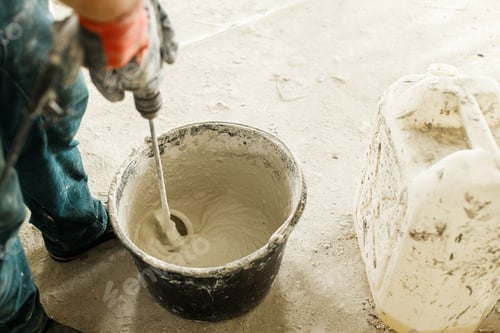 Preview: Worker mixing gypsum plaster with water for plastering walls