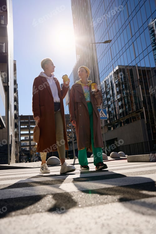 Preview: Brunette and blonde, lgbt couple, walking in the city streets