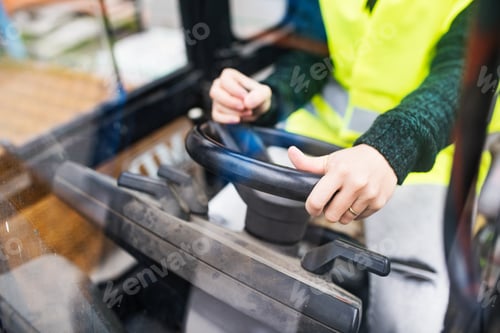 Preview: Woman forklift truck driver in an industrial area.