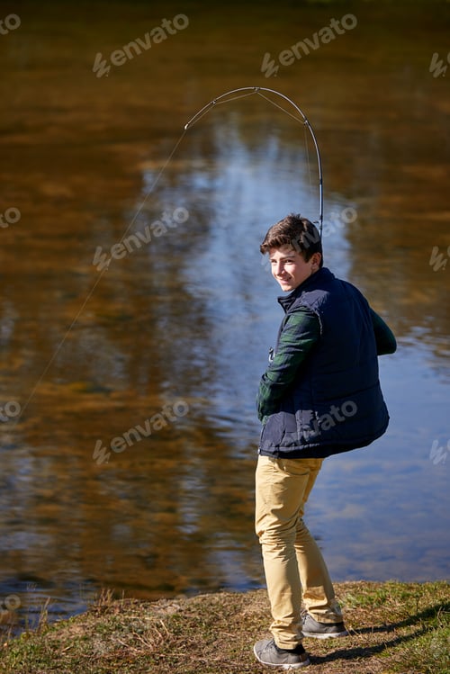 Preview: Fish tremble when they hear my name. Shot of a young boy fishing by a lake.