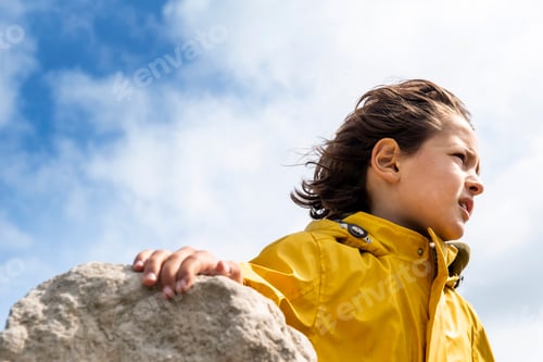 Preview: Boy beside rock with breeze in hair