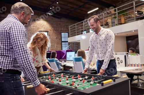 Preview: Business people in office taking a break, playing foosball