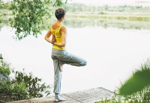 Preview: Young smiling woman practice yoga outdoors