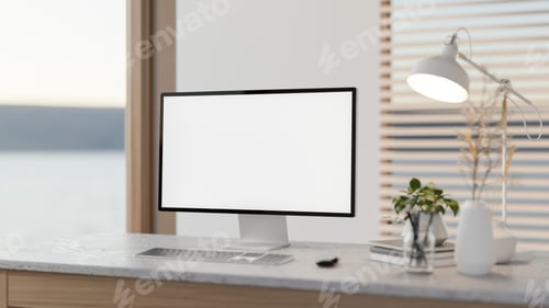 Preview: White screen computer with books and decors aside lamp on marble table in a bedroom or living room.