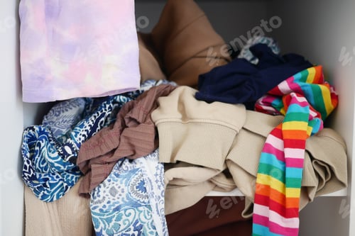 Preview: Messy closet with piled clothes and colorful accessories, displaying chaos and disorder in storage