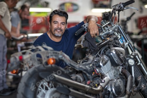Preview: Portrait of smiling mechanic in motorcycle workshop