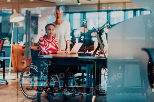 Preview: Businesswoman in a wheelchair working in a creative office. Business team in modern coworking