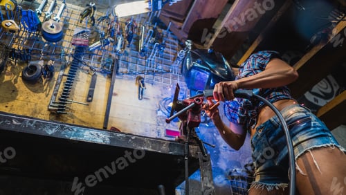 Preview: Welder Girl. A Girl With A Welding Machine Welds Metal.