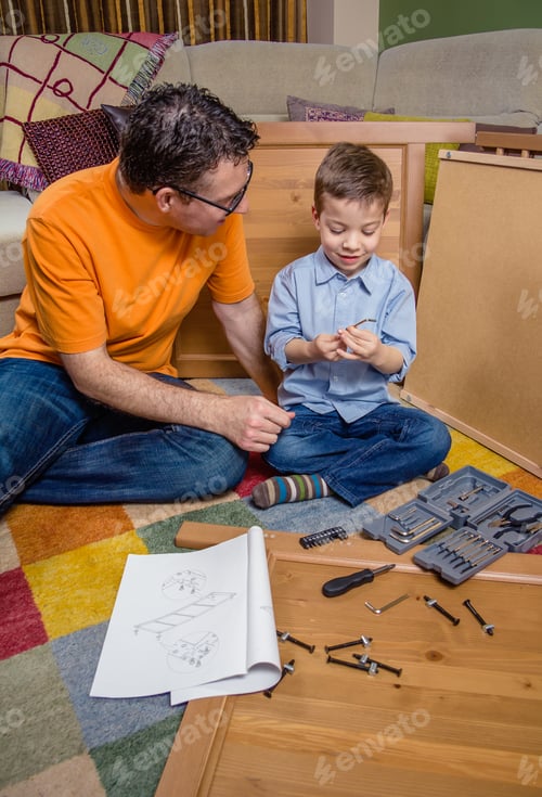 Preview: Father and son assembling a new furniture for home