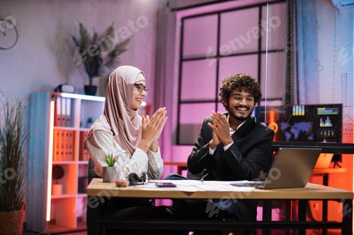 Preview: Happy overjoyed multiracial business people, muslim businesswoman and male broker getting good news