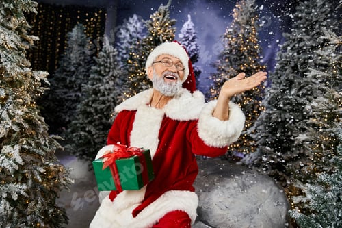 Preview: A jolly Santa Claus joyfully celebrates the festive spirit among shimmering snow and trees