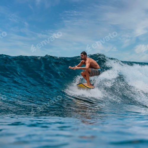 Preview: Shirtless male surfer on a wave at sunny day