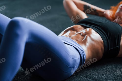 Preview: Close up view. Sporty redhead girl have fitness day in gym at daytime. Muscular body type