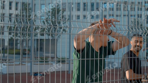 Preview: Young sportsman posing at basketball court. Media. Guy looking at camera behind the fence at a