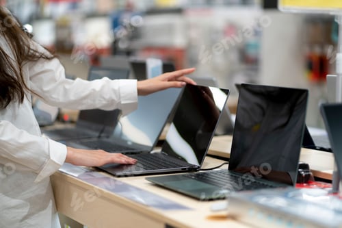 Preview: a client in a retail shop choosing a new laptop for studying and working