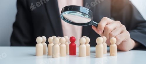 Preview: Businesswoman hand holding magnifying glass for recruiting leader man wooden from crowd of employees