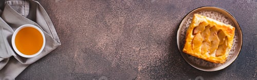 Preview: Small upside down puff pastry cake with apple on a plate top view web banner