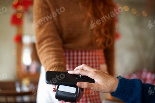 Preview: Customer in cafe making contactless payment with mobile phone