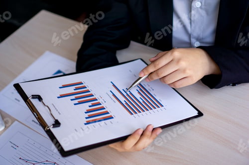 Preview: Asian female chief financial officer pointing at documents Company performance based on numbers and