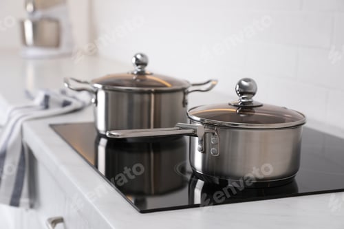 Preview: New clean pot and saucepan on cooktop in kitchen