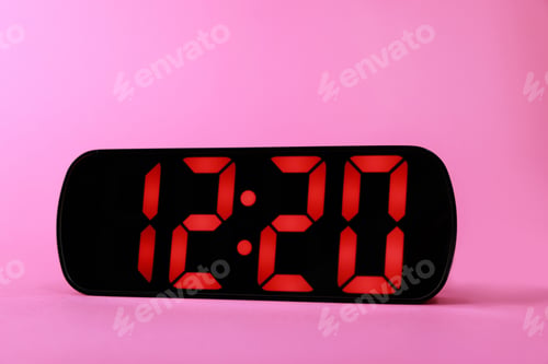 Preview: Digital alarm clock showing 12:20 o'clock on pink background, closeup