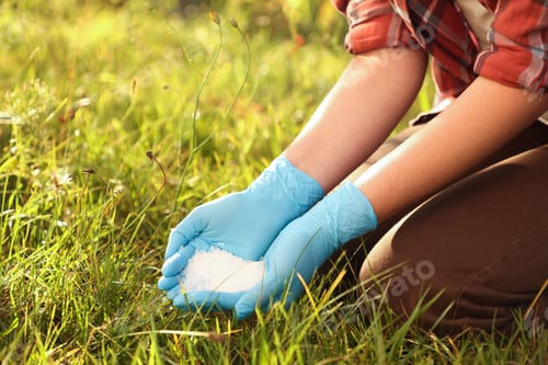 Preview: Woman with fertilizer outdoors, closeup. Gardening time