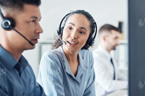 Preview: Shot of two call centre agents working together on a computer in an office