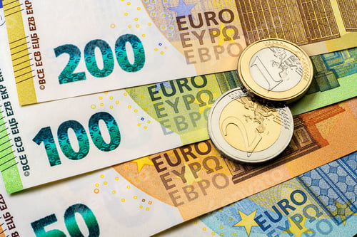 Preview: Various of Euro banknotes arranged on a surface alongside two Euro coins.