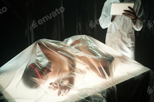 Preview: Young African male scientist with tablet standing by table with cyberpunk girl