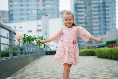 Visualização: Jovem menina caminhando alegremente no parque da cidade segurando uma flor em um dia ensolarado