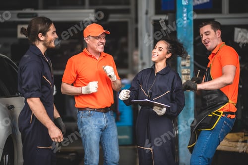 Preview: a portrait group photo of machanic team smiling in front of garage with thumb up